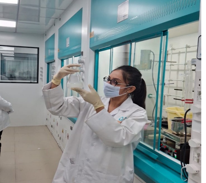 Chemist Evaluating Synthesized Intermediate Compound in Reaction Flask